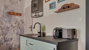 Modernilla designilla varustettu keittiö, jossa on musta hana, sisäänrakennettu kahvinkeitin ja leivänpaahdin.