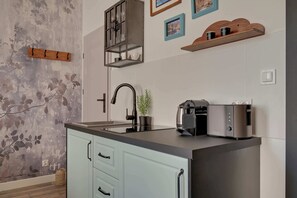 Eine Küche mit modernem Design, mit einem schwarzen Wasserhahn, einer integrierten Kaffeemaschine und einem Toaster.