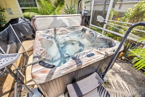 A hot tub with a control panel, surrounded by a metal railing, and a step leading into it. - Right Direction Rentals Tropical Haven Retreat (Port St Lucie)