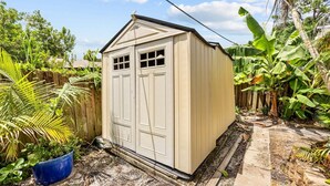 Un petit abri de plain-pied, doté d’un toit à deux versants et d’une porte avec une fenêtre.