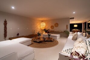 Ein modernes Wohnzimmer mit einer Couch, einem Couchtisch und einer Pendelleuchte.