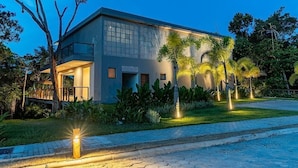 A modern building with a flat roof, large windows, and a well-lit entrance. - 159M- Casa de Luxo em Trancoso-BA  (Porto Seguro)