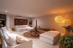 Ein modernes Wohnzimmer mit einem Ecksofa, einem runden Couchtisch und einem großen Fenster.