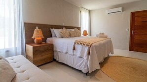 A bedroom with a bed, nightstands, a wooden dresser, and a large window. - 159M- Casa de Luxo em Trancoso-BA  (Porto Seguro)