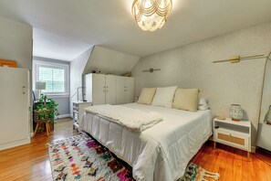 A bedroom with a bed, bedside tables, a lamp, a window, and a ceiling light fixture. - Walk to Village District! Charming Escape w/ Yard (Raleigh)