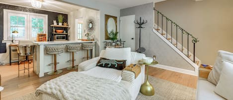 A modern living room with a sofa, a coffee table, and a staircase.