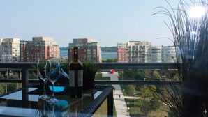 Ein Balkon mit Tisch, Weinglas, Flasche und Topfpflanze.
