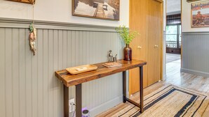 A hallway with a wooden console table, a welcome sign, and a framed picture on the wall. - New! Riverfront Trout Fishing White River Ozarks (Cotter)