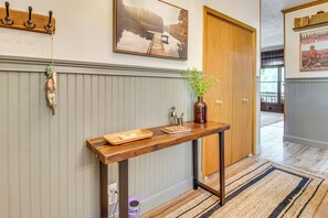 A hallway with a wooden console table, a welcome sign, and a framed picture on the wall. - New! Riverfront Trout Fishing White River Ozarks (Cotter)
