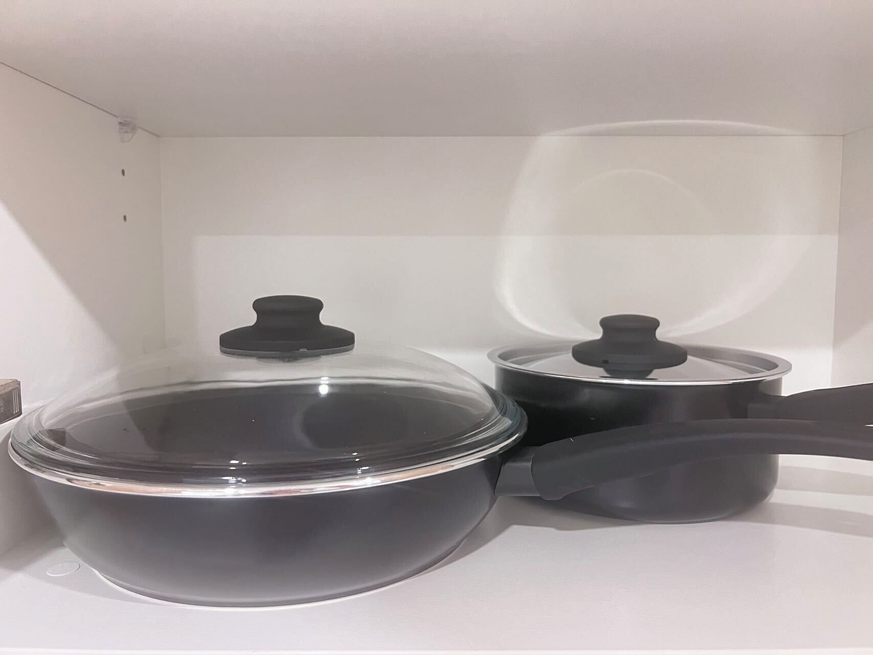 A kitchen with a stove, a large pot, and a smaller pot with lids.