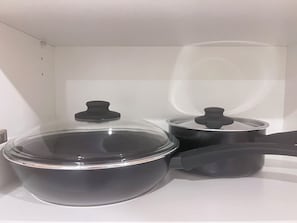 A kitchen with a stove, a large pot, and a smaller pot with lids. - Cozy studio in CBD (Padstow)