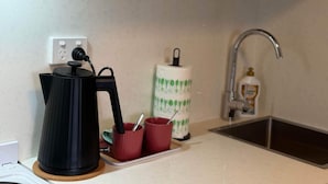 Eine Küche mit Kaffeemaschine, Papierhandtuchspender und Seifenspender.