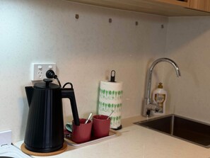 Eine Küche mit Kaffeemaschine, Papierhandtuchspender und Seifenspender.