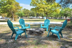 A circular seating arrangement with four chairs around a central fire pit in an outdoor setting. - Walk to Oak Island Beach! Casablanca Estate (Oak Island)