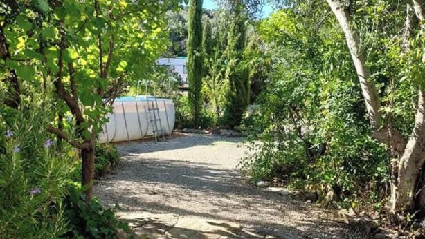 A stone pathway leading to a white boat docked in a garden with trees and greenery. - Traditional Country Home (São Brás de Alportel)