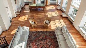 A spacious living area with a pool table, two wicker chairs, a patterned rug, and a sofa. - Villa La Limonera (Casciago)