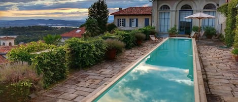 Ein Schwimmbecken mit Blick auf ein Haus und die Landschaft.
