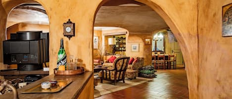 Un intérieur chaleureux avec un coin bar, un téléviseur et une horloge au mur.