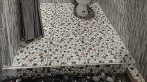 Un baño con inodoro, lavamanos y cortina de ducha.