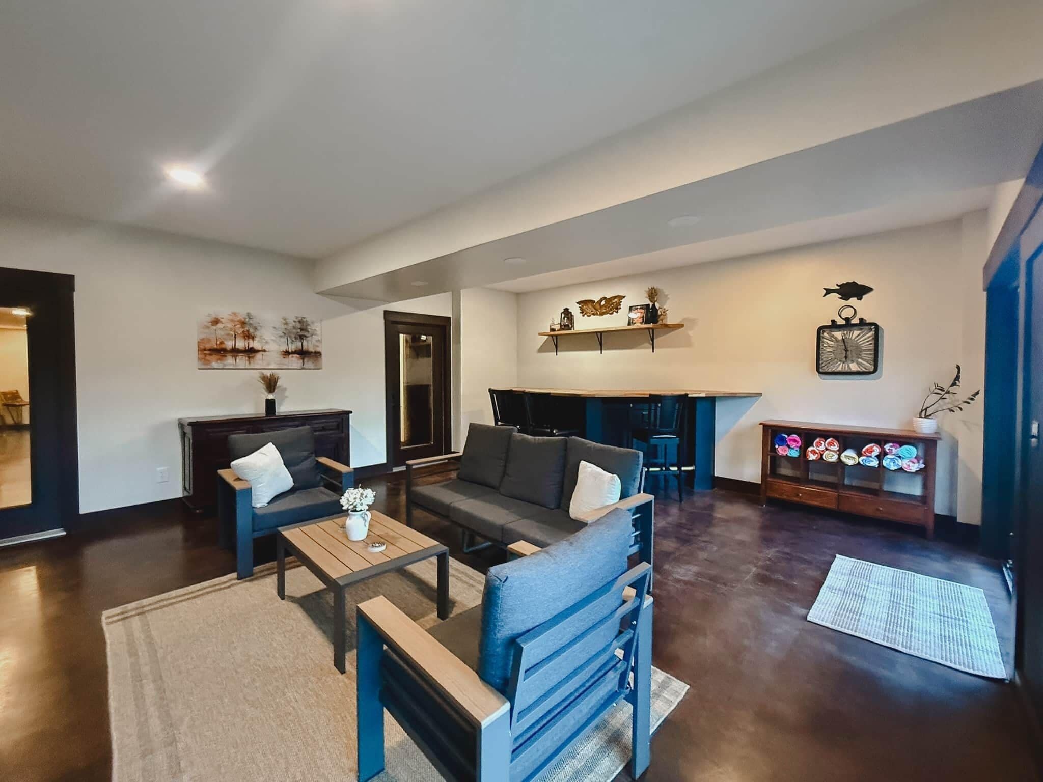 A modern living room with a sofa, coffee table, and a dining area with chairs.