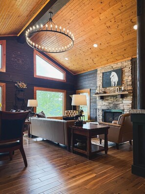 A cozy room with a fireplace, wooden ceiling, and a large window. - Dutton Chapel Lodge (Golconda No. 2 Precinct)