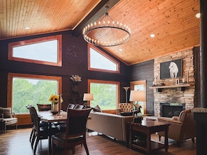 A spacious room with a high ceiling, large windows, a fireplace, and a dining area. - Dutton Chapel Lodge (Golconda No. 2 Precinct)