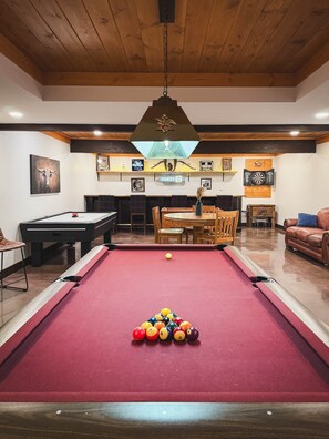 A pool table with balls, a billiards table, a wooden ceiling, and a hanging light fixture. - Dutton Chapel Lodge (Golconda No. 2 Precinct)