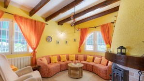 Ein gemütliches Wohnzimmer mit einer gebogenen Couch, einem runden Couchtisch und einem Kamin.