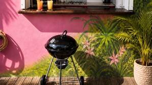 Una cucina con microonde, forno e macchina da caffè, un barbecue e una pianta in vaso.