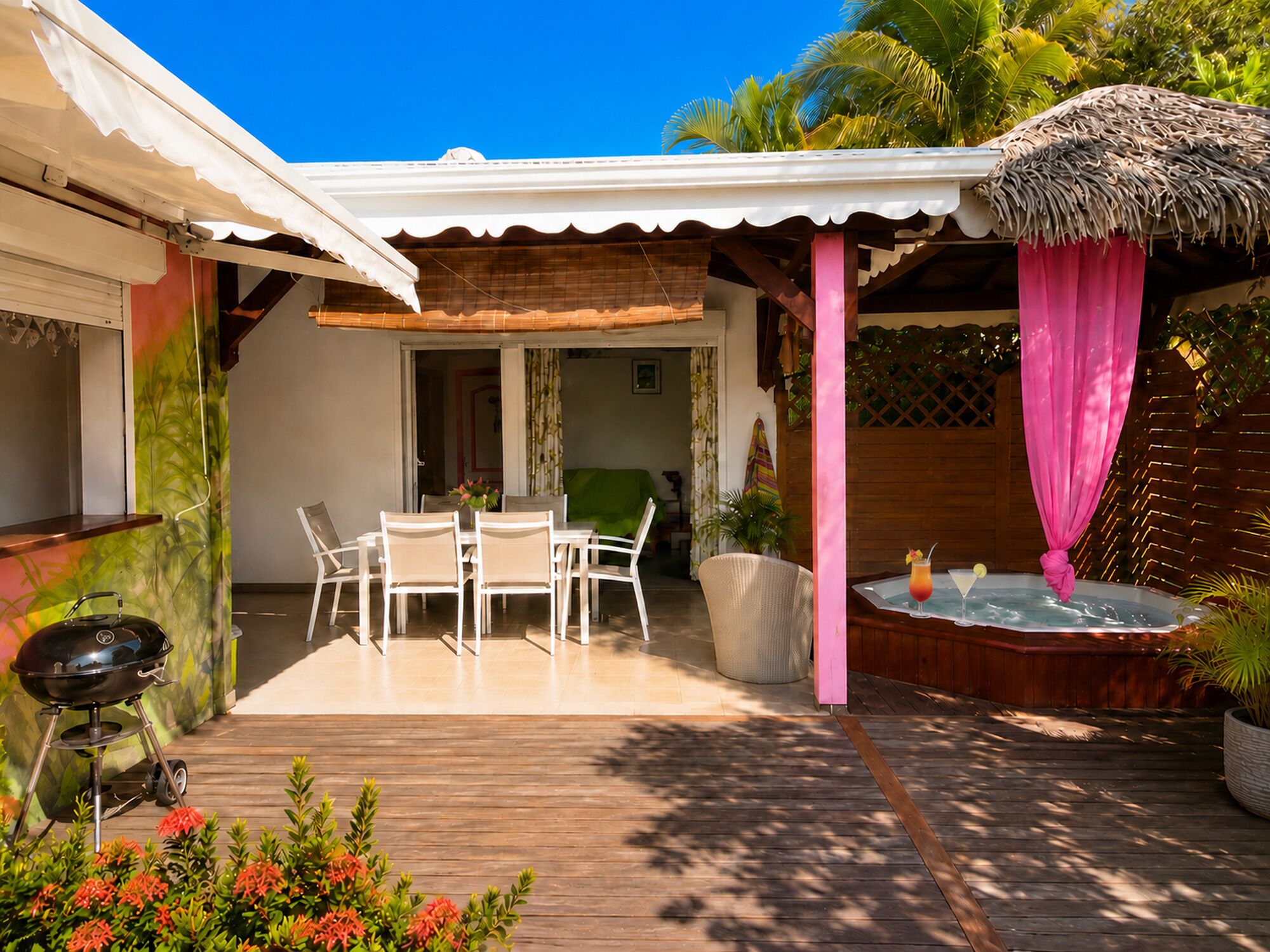 A patio area with a table and chairs, a hot tub, and a barbecue grill.