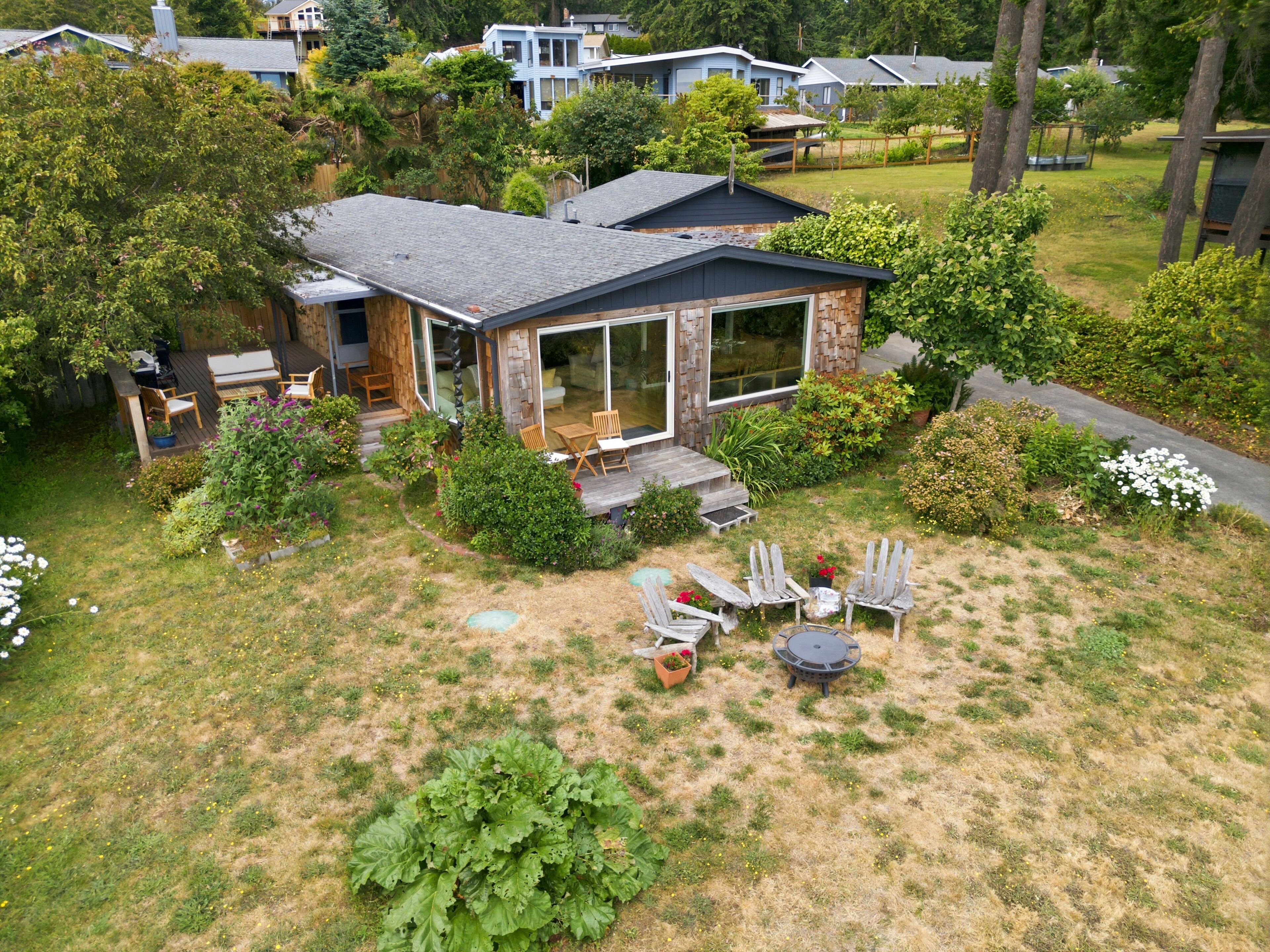 A house with a patio, outdoor seating, and a garden.