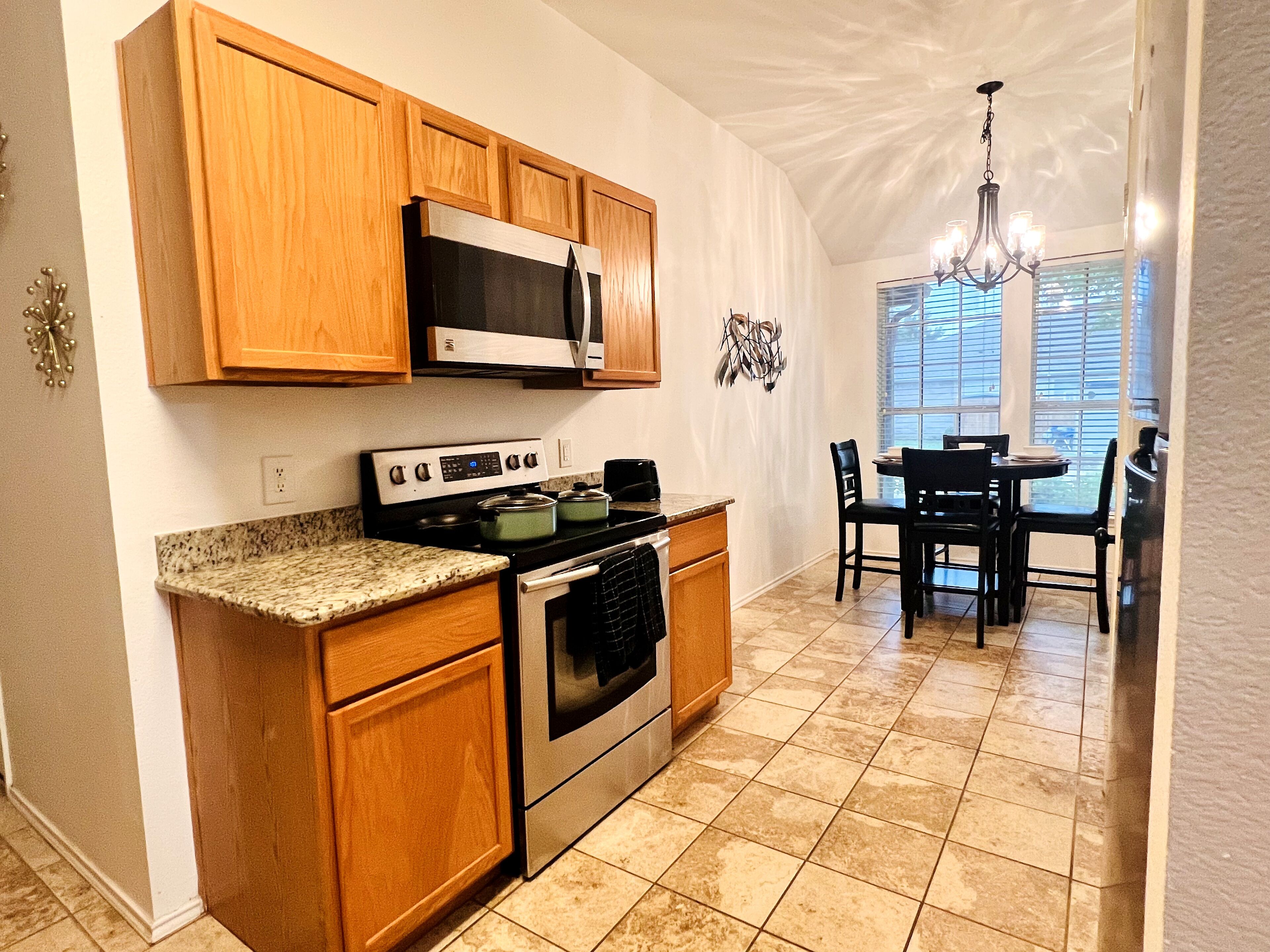 A kitchen with wooden cabinets, a stove, and a microwave.