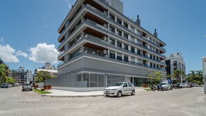 Ein mehrstöckiges Gebäude mit modernem Design, mit Balkonen und großen Fenstern.