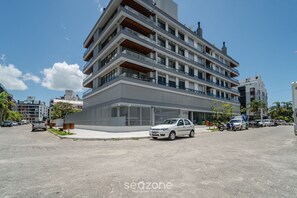 Ein mehrstöckiges Gebäude mit modernem Design, mit Balkonen und großen Fenstern.