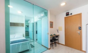 A hotel room with a bed, a desk, and a door. - Apt. in Condo. w/ sea View and gym Sip0206 (Salvador)