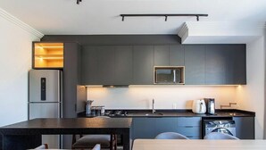 A modern kitchen with a built-in microwave, a refrigerator, and a sink. - Spacious Apartment Near Beto Carrero Lav0303 (Penha)