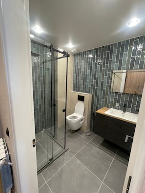 Suite monolocale, balcone, vista mare parziale | Bagno | Doccia, asciugacapelli, asciugamani, sapone