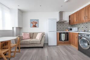 Eine moderne Küche mit Kühlschrank, Backofen, Mikrowelle und Waschmaschine.