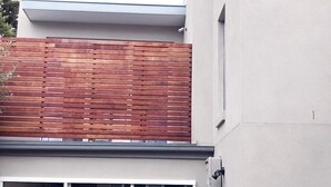 Ein modernes Gebäude mit einem großen Glastür-Eingang, einem Holzschottenzaun und freiem Blick ins Innere.