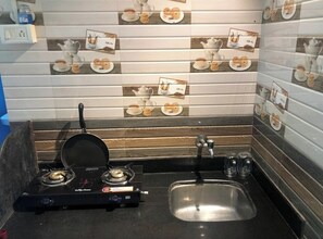 Eine Küche mit Gasherd, Spüle und dekorativer Spritzschutz.