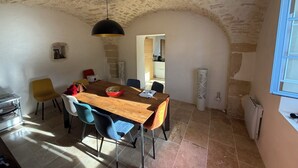 Un'area pranzo con tavolo in legno, sedie e lampadario.