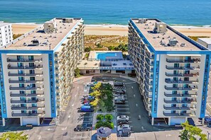 A high-rise hotel with multiple floors, a parking lot, and a beach view. - Oceanfront 2 Bed 2 Bath Condo with Pool! Braemar Towers 1804 (Ocean City)