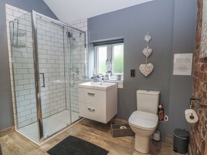Ein modernes Badezimmer mit Duschkabine aus Glas, einem weißen Waschbecken und einer Toilette.