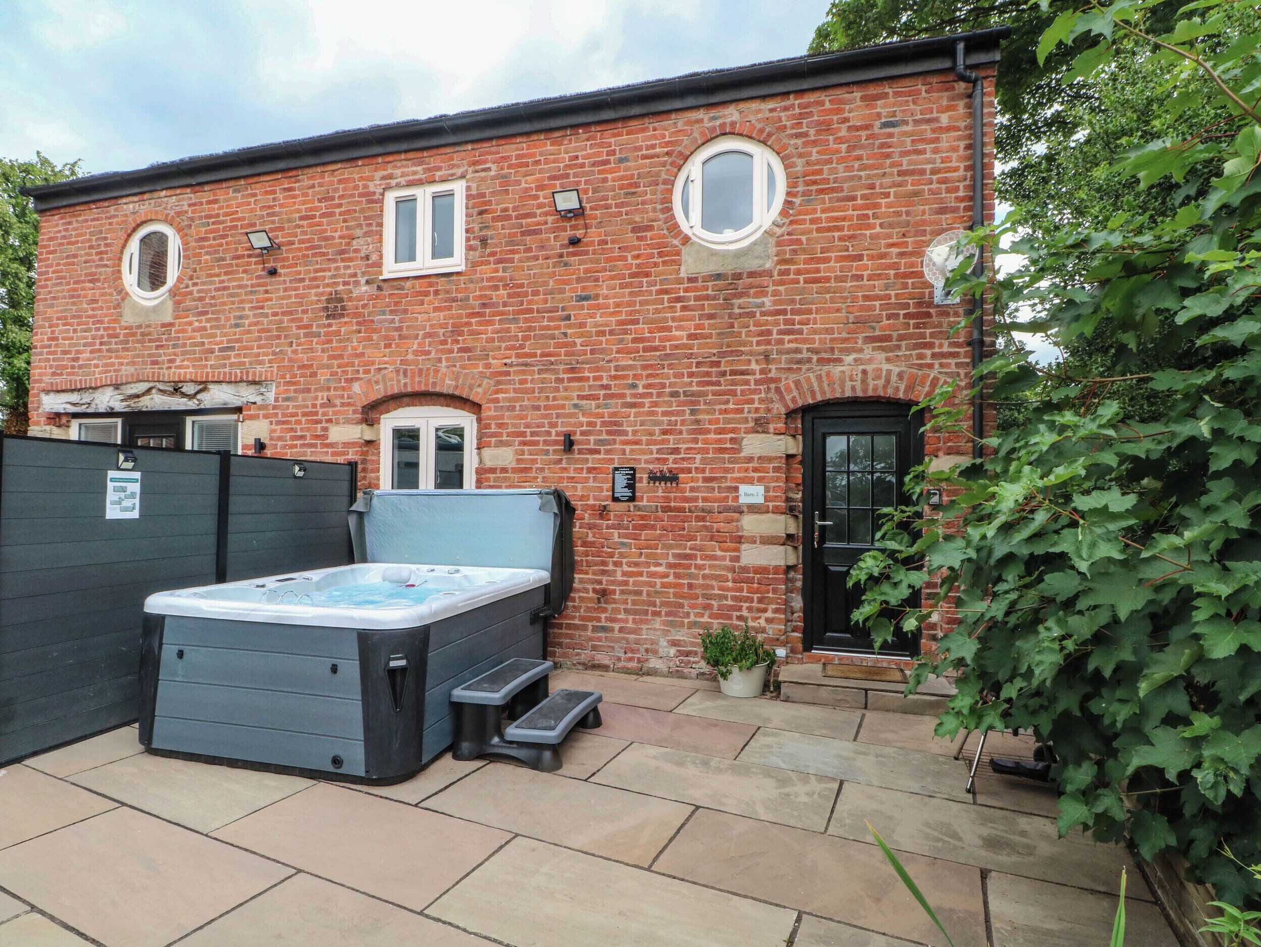 A brick building with a hot tub, steps, and a door.