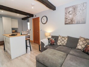 A living room with a sofa, a lamp, and a wall clock. - Barn 2 (Sandbach)