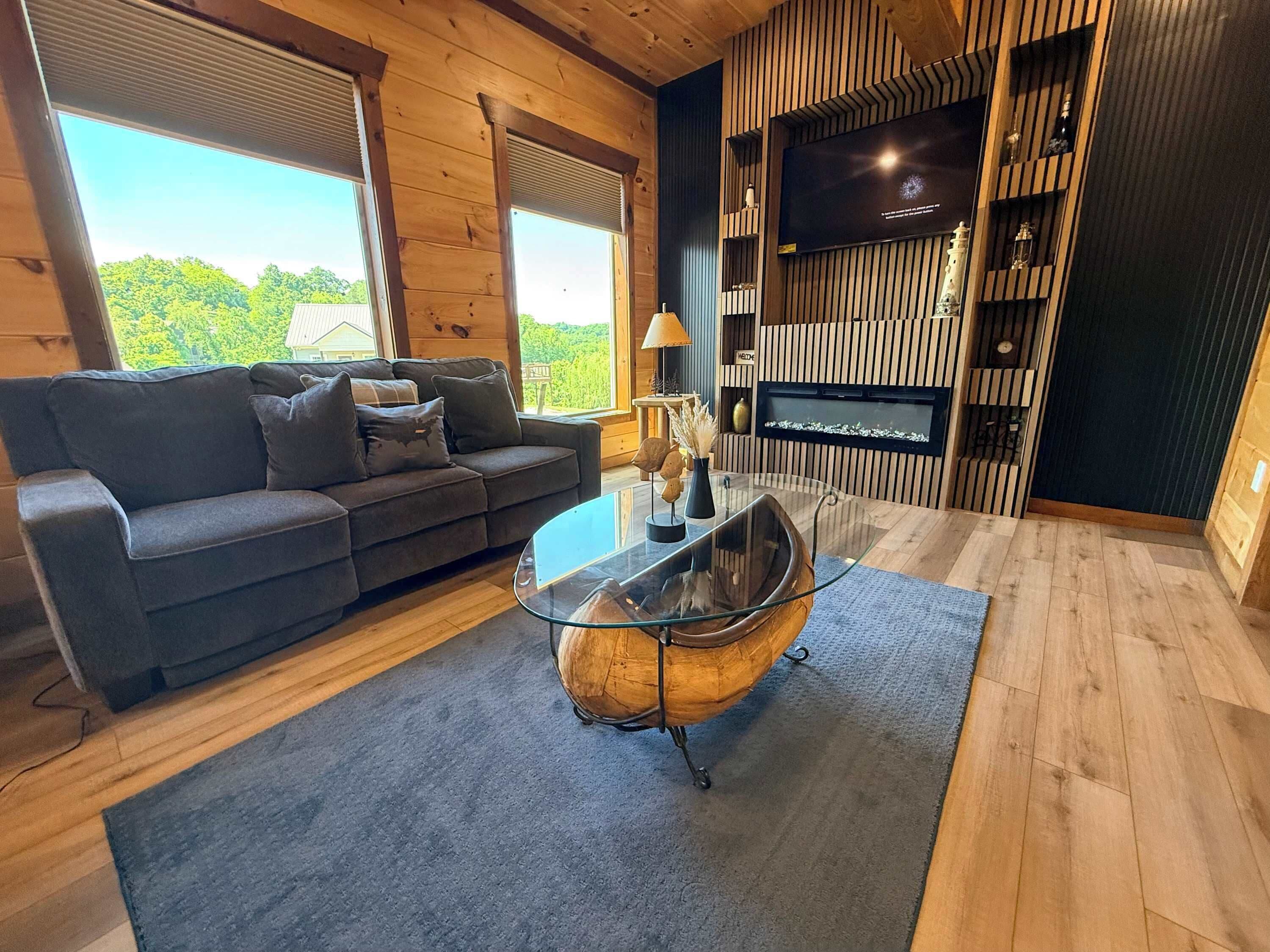A modern living room with a sofa, a glass coffee table, and a fireplace.