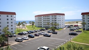 A hotel with a parking lot, multiple floors, and a view of the beach. - 151 El Matador 2 Bedroom Condo (Fort Walton Beach)