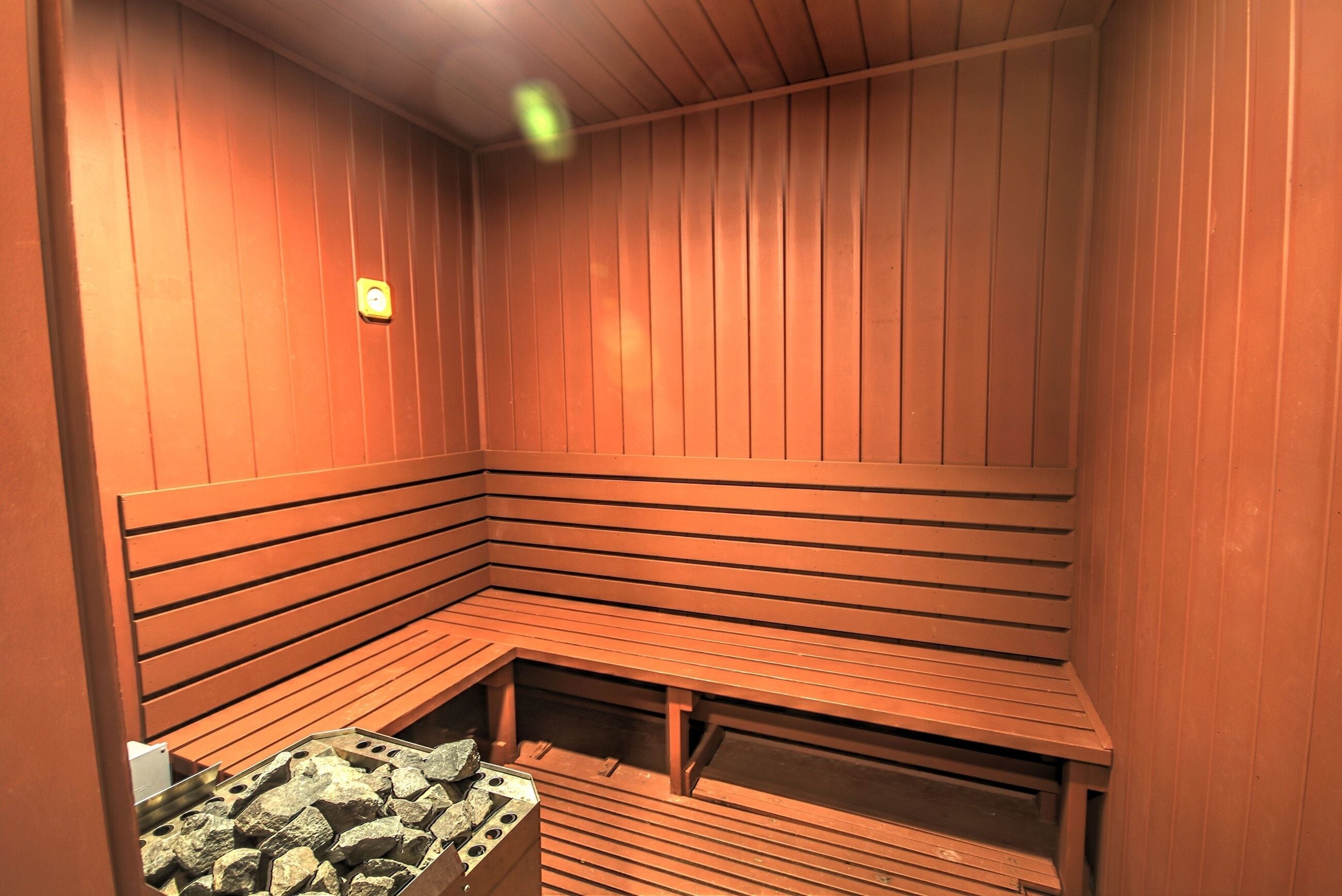 A sauna with wooden benches and a stone bench.