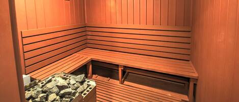 A sauna with wooden benches and a stone bench.