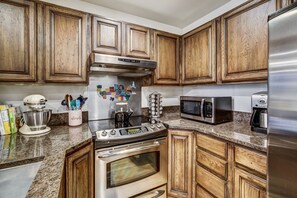 A kitchen with wooden cabinets, stainless steel appliances, and a granite countertop. - Premium Arrowhead Village 1br Condo Walk To Lift! 1 Bedroom Condo (Edwards)